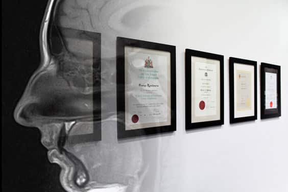 framed medical degrees and certificates on a wall